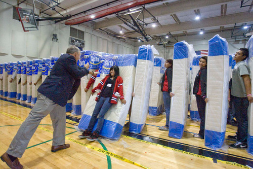 Paul Fraughton  |  The Salt Lake Tribune
Curt Crowther, president of Serta Mattress Co. pushes Eisenhower Junior High Student Body President, Roxana Martinez whose fall starts the domino chain reaction in the junior high's attempt to break a Guinness world record for thehuman/mattress domino chain.