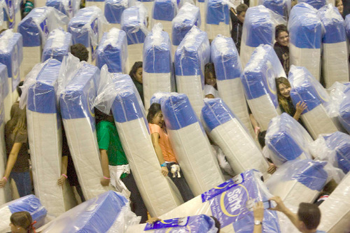 Paul Fraughton  |  The Salt Lake Tribune    Students, faculty and friends  at Eisenhower Junior High  smile as they are toppled by mattresses in their attempt to break a Guinness world record for a human/mattress domino chain.  With over 600 mattress furnished by RC Willey and Serta Mattress Company, school officials feel confident that the record 620 mattresses  downed in 21.43 seconds  will  be verified by the Guinness judges. Wednesday,October 20, 2010