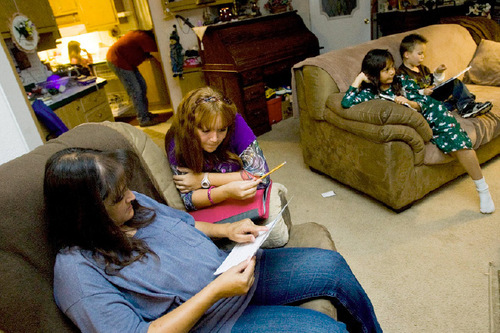 Djamila Grossman  |  The Salt Lake Tribune 
Brenda Chambers and her daughter, Kylie Chambers, 11, work together on homework as siblings Ashley Chambers, 8, and Dominick Kirkwood, 5, read and father Jason Chambers cleans the kitchen Thursday at their Wellington home. Kylie, who has asthma, is on the Children's Health Insurance Program. Recent changes in the program have forced the parents to drive more than 60 miles for their daughter to see a doctor.