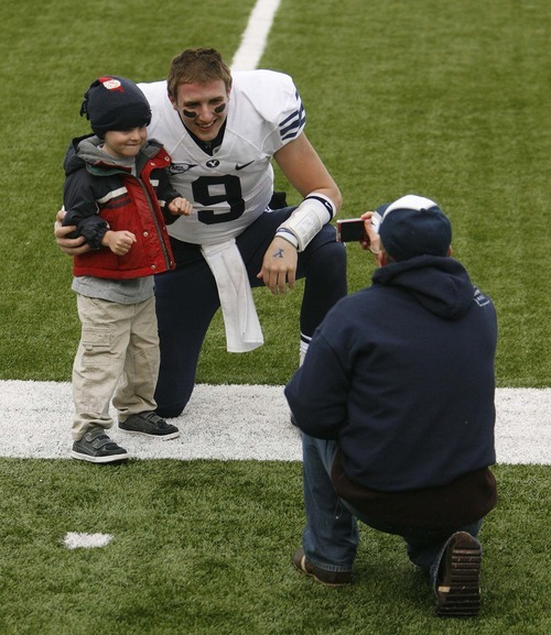 Trent Nelson  |  The Salt Lake Tribune
BYU quarterback Jake Heaps (9) poses with a young fan. BYU vs. Colorado State, college football, Saturday, November 13, 2010. BYU won 49-10.