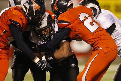 Chris Detrick  |  The Salt Lake Tribune 
Highland's Sione Houma #35 runs through Tennyson George #24 during the first half of the 4A Utah State Championship game at Rice-Eccles Stadium Friday November 19, 2010.  Mountain Crest is winning the game 9-7.