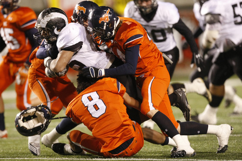 Chris Detrick  |  The Salt Lake Tribune 
Highland's Sione Houma #35 is tackled by Mountain Crest's Moroni Lee #8 and Taylor Root #20 during the first half of the 4A Utah State Championship game at Rice-Eccles Stadium Friday November 19, 2010.  Mountain Crest is winning the game 9-7.