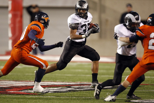 Chris Detrick  |  The Salt Lake Tribune 
Highland's Sione Houma runs past Mountain Crest's Taylor Root on Nov. 19. Houma has committed to play for Michigan.