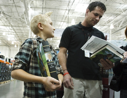 Leah Hogsten  |  The Salt Lake Tribune
Andre Holewinski, 11, (left) and his father Robert Holewinski of Eagle Mountain were near the front of the line to meet former President George W. Bush at a book-signing Friday at Costco in Sandy. Holewinski served three tours in Iraq.