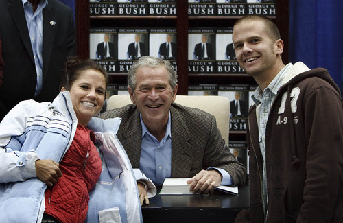 Leah Hogsten  |  The Salt Lake Tribune
An unidentified couple share a light moment with former President George W. Bush on Friday as he signed copies of his new memoir at Costco in Sandy.
