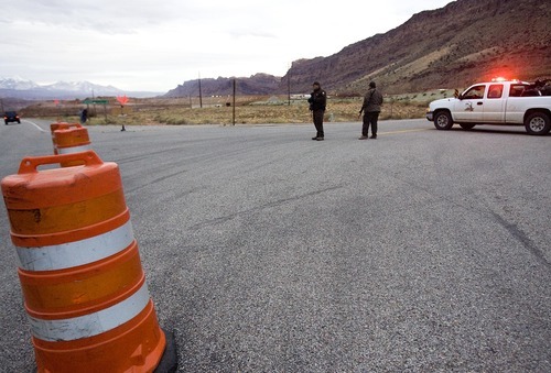 Djamila Grossman  |  The Salt Lake Tribune

Two State Park rangers stand guard with rifles at the blocked SR 279 near Moab, Saturday, Nov. 20, 2010. The road has been closed to the public while officers search for a suspect in an officer-involved shooting.