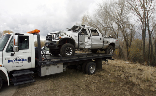 Francisco Kjolseth  |  The Salt Lake Tribune
Truck is hauled away after crashing on I-84 near South Ogden on Monday. A medical helicopter responding to the crash was disabled after it clipped its tail rotor on a highway reflector post. The driver of the truck was taken to a hospital in serious condition, while no one aboard the helicopter was injured.