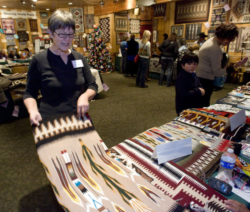 Steve Griffin  |  The Salt Lake Tribune
Mary Phillips talks with Navajo weavers as she looks at a rug during the 21st Annual Navajo Rug Show and Sale in the Snow Park Lodge at Deer Valley in Park City on Friday. After her teenager daughter was killed by a drunk driver years ago, Phillips decided to find a way to give back during the holidays to other teenagers - who are often left out of mainstream Christmas programs. Each year her family helps another family with teenagers during the holiday season. In her other life, she does development work for the Adopt-A-Native-Elder Program.