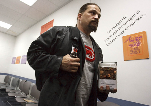 Leah Hogsten  |  The Salt Lake Tribune
Jason Park on Wednesday carries one of three jars of pennies collected to feed the homeless. Drug court assigned students in an education program at Salt Lake County's criminal justice division are giving back to the community for the holidays. Instructor Meredith Franck challenged the class to collect their pennies to feed one homeless person on Thanksgiving. The class gathered enough to feed at least 40 people.