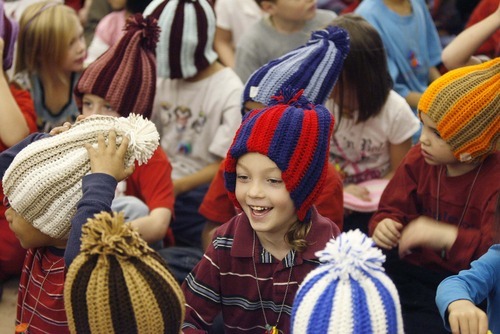 Paul Fraughton  |  The Salt Lake Tribune   T.J. Darling, a first-grader at Oquirrh Hills elementary School in Kearns, smiles after putting on a new winter hat made by prison inmate Robert E. Jones on Friday,December 3, 2010.
