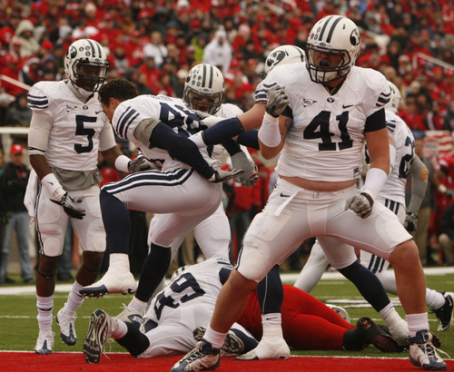 Trent Nelson  |  The Salt Lake Tribune

BYU defensive lineman Matt Putnam (41) and other BYU players celebrate stopping Utah Utes running back Eddie Wide #36 as the Utes face BYU in the first quarter at Rice-Eccles Stadium Saturday, November 27, 2010.