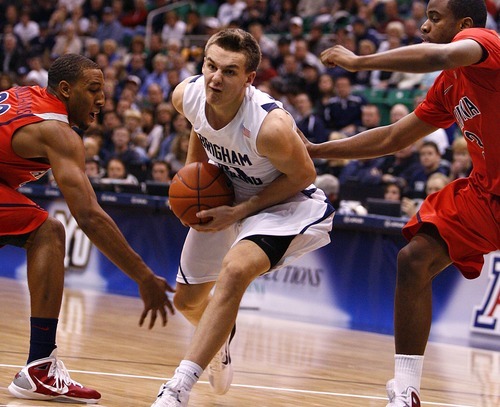 Djamila Grossman  |  The Salt Lake Tribune

Brigham Young University's Kyle Collinsworth, 31, drives the ball toward the basket as the University of Arizona's Kevin Parrom, 3, and Derrick Williams, 23, block him, in a game in Salt Lake City, on Saturday, Dec. 11, 2010. BYU won the game.