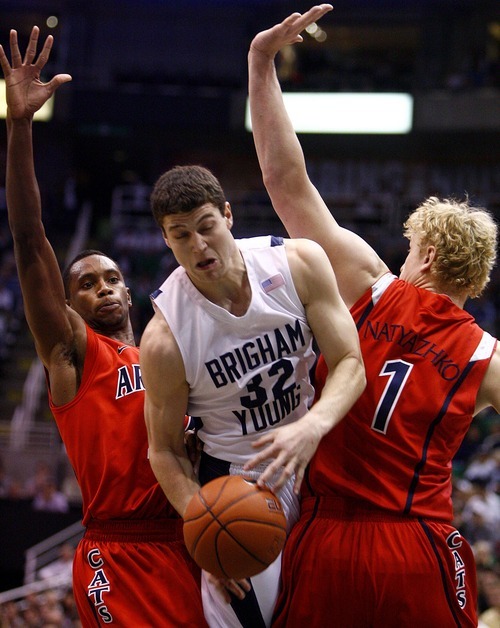 Djamila Grossman  |  The Salt Lake Tribune

Brigham Young University's Jimmer Fredette, 32, falls as he is blocked by the University of Arizona's Kyryl Natyazhko, 1, and Kyle Fogg, 21, during a game in Salt Lake City, on Saturday, Dec. 11, 2010. BYU won the game.