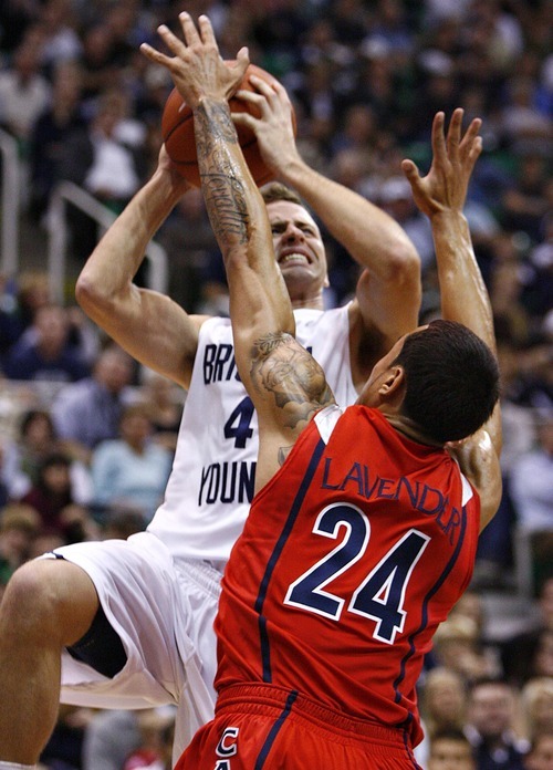 Djamila Grossman  |  The Salt Lake Tribune

Brigham Young University's Jackson Emery, 4, is blocked by the University of Arizona's Brendon Lavender, 24, during the second half of a game in Salt Lake City, on Saturday, Dec. 11, 2010. BYU won the game.