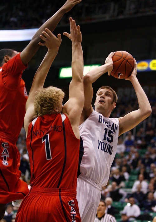 Djamila Grossman  |  The Salt Lake Tribune

Brigham Young University's James Anderson, 15, goes in to score as he is blocked by the University of Arizona's Kyryl Natyazhko, 1, during the first half of a game in Salt Lake City, on Saturday, Dec. 11, 2010.