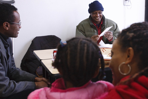 Leah Hogsten  |  The Salt Lake Tribune
Terefe Abtew Mekonnen smiles on Saturday as he reads his holiday cards filled with donations from good friend Firehiwot Abebe, in the foreground, holding her daughter Hiwot Ray, 4, who stopped by the Overseas Groceries store to visit with him on Saturday. At left is Michel Mamo director of the Ethiopian Community Association of Utah. The Ethiopian community supporters of Terefe Abtew Mekonnen  gathered Saturday, December 18, 2010,  to launch a major fund-raising drive on behalf of Terefe and his family for humanitarian contributions from Utahns. Terefe Abtew Mekonnen has been diagnosed with end-stage renal disease stemming from a long-standing diabetes. To sustain his life, Terefe has been receiving dialysis three times a week for the last year, but he needs a kidney transplant at the cost of  about $100,000 to $150,000.  Donation boxes are placed at Overseas Groceries on 1532 South State Street in Salt Lake City.