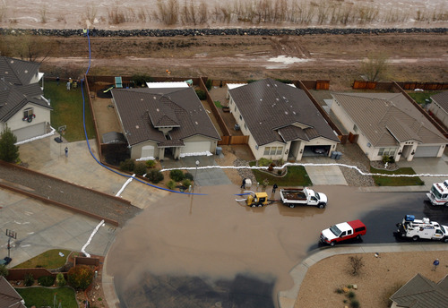 Rick Egan   |  The Salt Lake Tribune

Residents pump water from the street in front of their home in Saint George, Tuesday, December 21, 2010