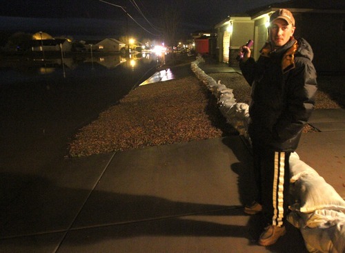 Rick Egan   |  The Salt Lake Tribune

Nathan Barrow checks out the flooding situation near his home in Stonegate subdivision, in Washington, Utah,  Tuesday, December 21, 2010. Crews from Washington City were still pumping the water out of the streets late Tuesday night.