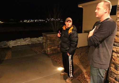 Rick Egan   |  The Salt Lake Tribune

Nathan Barrow (left) and Danny Kemp,(right) check out the situation in their neighborhood, in Stonegate subdivision, in Washington, Utah,  Tuesday, December 21, 2010. Crews from Washington City were still pumping the water out of the streets late Tuesday night.