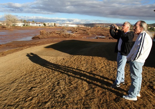 Rick Egan   |  The Salt Lake Tribune

Herm Rusler and Grant Davis stop to take a few photos of  the damage to the Southgate golf club in Saint George , Utah, Thursday, December 23, 2010.   Flood waters damaged four holes and totally destroyed the 9th fairway.
