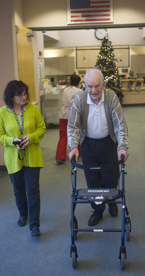 Al Hartmann  |  The Salt Lake Tribune 
Gilbert Gooch, a resident at the Utah State Veterans Nursing Home in Salt Lake City, walks to the dining room with staff member Bernadette Montoya.