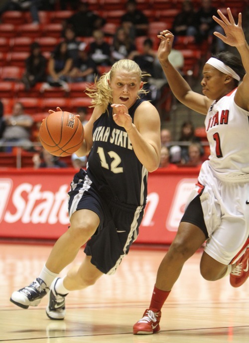 Rick Egan   |  The Salt Lake Tribune

Utah State's Jenna Johnson, (12)  dribbles past, Janita Badon (1) defends for the Lady Utes, in Basketball action Utah vs. Utah State at the Huntsman Center,  Saturday, January 1, 2011