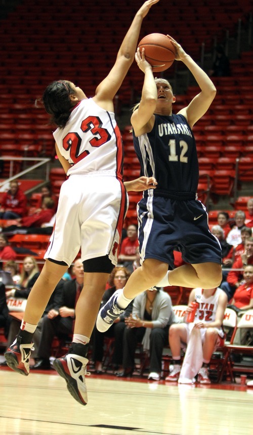 Rick Egan   |  The Salt Lake Tribune

Jenna Johnson, (12) takes a shot for Utah State, as Brittany Knighton (23) defends for the Lady Utes, in Baskteball action Utah vs. Utah State at the Huntsman Center,  Saturday, January 1, 2011