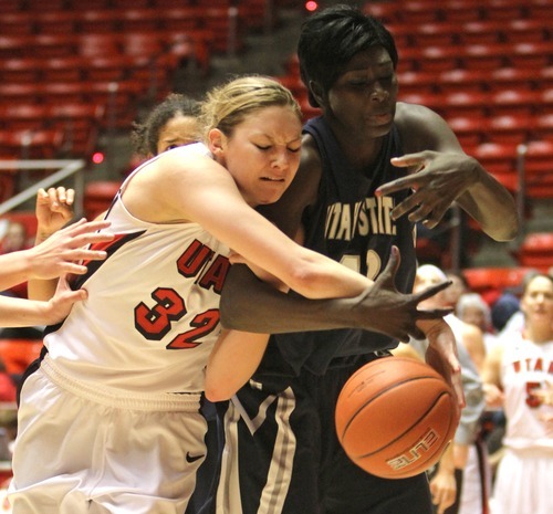 Rick Egan   |  The Salt Lake Tribune

Diana Rolniak battles Utah State's Banna Diop for the ball, in Baskteball action Utah vs. Utah State at the Huntsman Center,  Saturday, January 1, 2011