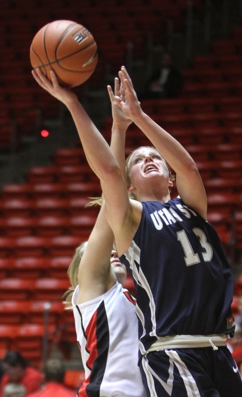 Rick Egan   |  The Salt Lake Tribune

Alice Coddington (13) shoots the ball for Utah State, Diana Rolniak (32) defends for the Lady Utes, in Basketball action Utah vs. Utah State at the Huntsman Center,  Saturday, January 1, 2011