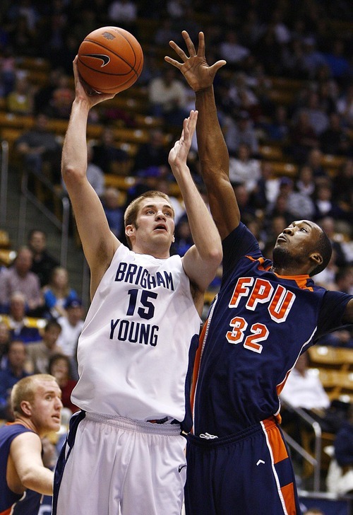 Djamila Grossman  |  The Salt Lake Tribune

Brigham Young University's James Anderson, 15, gets blocked by Fresno Pacific University's Jerante Morgan, 32, during the second half of a game in Provo, Saturday, Jan. 1, 2011. BYU won the game.