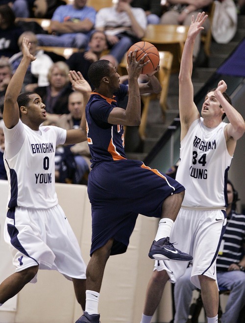 Djamila Grossman  |  The Salt Lake Tribune

Brigham Young University's Noah Hartsock, 34, and Brandon Davies, 0, guard Fresno Pacific's Jerante Morgan, 32, during the second half of a game in Provo, Saturday, Jan. 1, 2011.