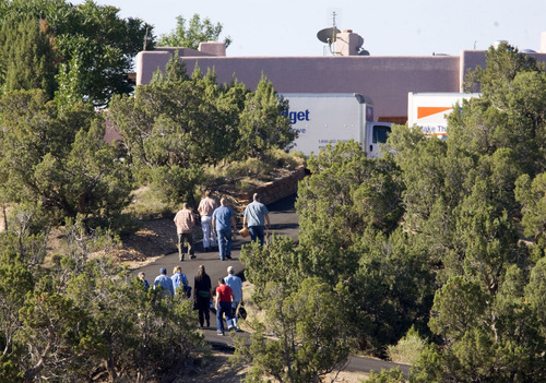 Al Hartmann  |  The Salt Lake Tribune 
Federal agents and archaeologists walk up the driveway to the Redd home south of Blanding on July 7th 2009 to search for and haul away  artifacts. Two moving trucks were parked next to the house to carry the artifacts. The turning over of artifacts was part of a plea deal with Jeanne Redd and federal prosecutors.