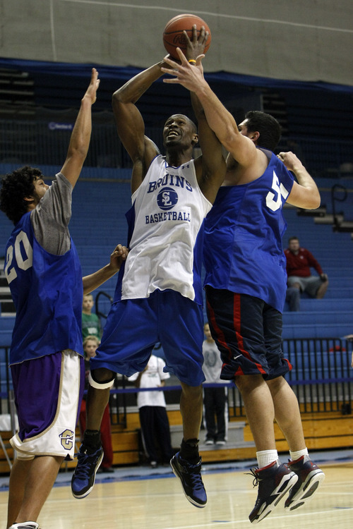 Chris Detrick  |  The Salt Lake Tribune
Chuck Overton #34, shoots past Chris Medina #20 and Tika Wesley #55 during the alumni game at Salt Lake Community Colleg. The Old Men team  defeated the Young Men team 71-65 in overtime.