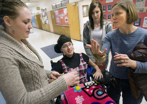 Al Hartmann  |  The Salt Lake Tribune 
Lina Nguyen was paralyzed in a car accident shortly before her junior year of high school. After a year and a half she's now returning to school at Granger High School to finish her senior year and graduate with her class.
Her first day back takes some planning with district physical therapist Lisa Mikavich, right, explaining how to take care of Lena's posture in her wheelchair with aides are Jennie Figueroa, left, and Cassandra Scott.