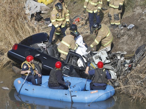 Rick Egan   |  The Salt Lake Tribune

Firefighters work Friday to remove the body of the driver of a car that flew over the pond from the off ramp from I-15 to 2100 South and smashed into a dirt embankment. The driver was identified as 21-year-old Maria L. Mejia. Police aren't sure when the accident happened and have no witnesses.