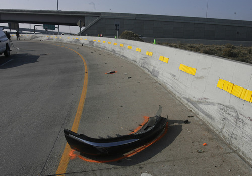 Rick Egan   |  The Salt Lake Tribune

Debris sit on the road as firefighters work to remove the body of the driver of a car that flew over the pond from the off ramp from I-15 to 2100 South and smashed into the embankment on the other side.