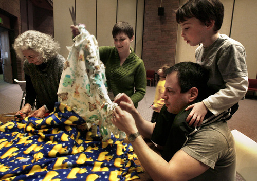 Scott Sommerdorf  l  The Salt Lake Tribune
As part of Mitzvah Day, Sheila Gelman (left), Rabbi Ilana Schwartzman, (center), and Micah Moskowitz (6 years) and his father Peter Moskowitz make fleece blankets for Project Linus to be distributed to hospitalized children, Sunday, 1/16/11. 
Congregation Kol Ami's religious school families and congregants are taking a day off from studying Jewish texts to put their Jewish values into action. Mitzvah Day is a day of service projects that will meet needs in the larger community.