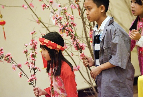 Djamila Grossman  |  The Salt Lake Tribune
The Vietnamese Community in Utah is celebrating the Lunar New Year with a big festival. From left, Lan Anh Vu, 7, Dean Pham, 10, and Rose Nguyen, 8, hold budding branches as they practice a dance at Lien Hoa Buddhist Temple in Taylorsville.