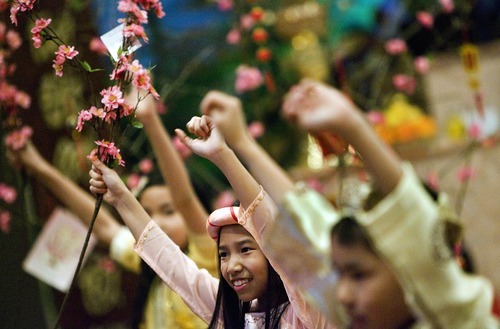 Djamila Grossman  |  The Salt Lake Tribune
Emily Nguyen, 10, and other children hold up branches as they practice a dance they will be performing during the Tet celebration.