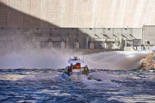 A Park Service boat approaches the base of the Glen Canyon Dam where water is surging into the Colorado River on   Wednesday, March 5, 2008.The water release is part of an ongoing experiment to see if a springtime influx of more water will improve fisheries downstream. 
Paul Fraughton /The Salt Lake Tribune; 3/5/08