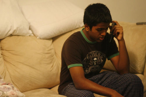 Chris Detrick  |  Tribune file photo
Kunal Sah talks with his parents on the phone at the Ramada Motel Dec. 17, 2008. His parents, Ken and Sarita, were denied political asylum and deported to India in 2006. Kunal stayed behind with an uncle but has joined his parents in India.