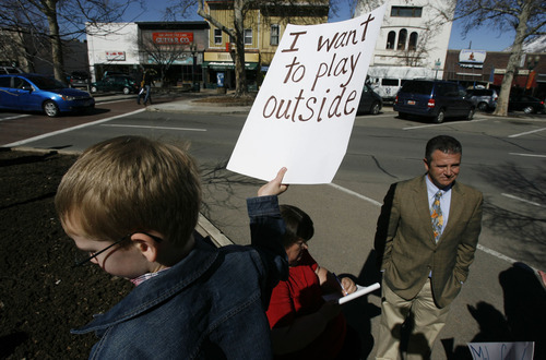 Francisco Kjolseth  |  The Salt Lake Tribune
Home-schooler David Whetten, 7, expresses his sentiments while Provo Council Chairman Rick Healey is interviewed outside the Provo City Center on Tuesday. The home-school group had planned to oppose a proposal to crack down on truants, but Mayor John R. Curtis asked the Municipal Council to withdraw the ordinance.