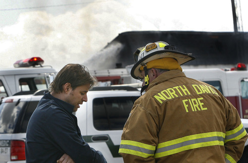 Scott Sommerdorf  |  The Salt Lake Tribune
Gary Clark, co-owner and chemical engineer at Clear Sky Biofuels, talks to a North Davis firefighter about his escape from the building after an explosion and fire that sent a fireball past his office door in Clearfield Friday. His business and an automotive repair business were destroyed.