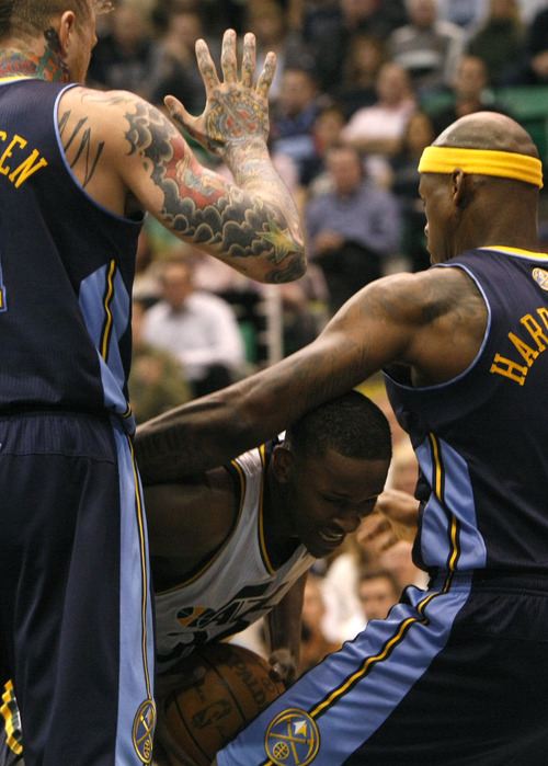 Photo by Chris Detrick | The Salt Lake Tribune 
Utah Jazz small forward C.J. Miles (34) is guarded by Denver Nuggets center Chris Andersen (11) and Denver Nuggets power forward Al Harrington (7) during the second half of the game at EnergySolutions Arena Thursday March 3, 2011.  Denver won the game 103-101.