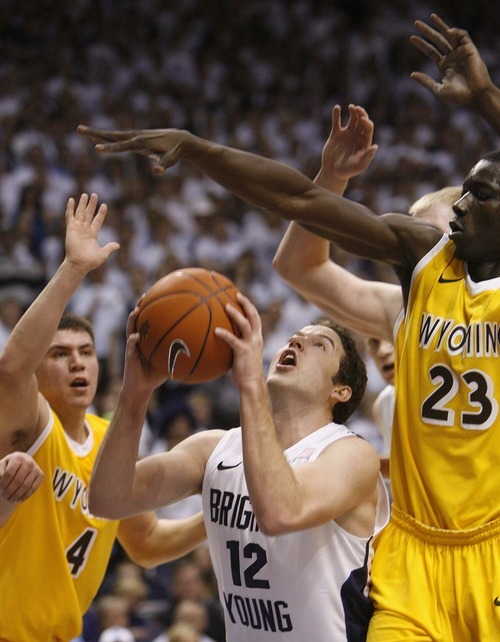 Trent Nelson  |  The Salt Lake Tribune
BYU's Logan Magnusson looks for a shot with Wyoming's Francisco Cruz, left, and Wyoming's Djibril Thiam defending as BYU hosts Wyoming, college basketball in Provo, Utah, Saturday, March 5, 2011.