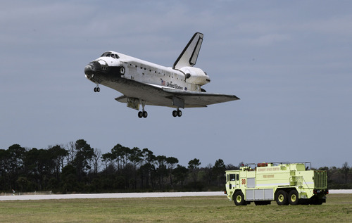 An emergency vehicle stands by near the runway as space shuttle Discovery lands at the Kennedy Space Center in Cape Canaveral, Fla., Wednesday, March 9, 2011. (AP Photo/John Raoux)