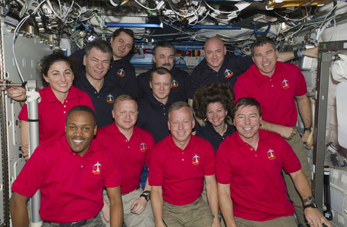 In this March 3, 2011 photo provided by NASA, inside the U.S. lab Destiny, 12 astronauts and cosmonauts take a break from a very busy week aboard the International Space Station to pose for a joint STS-133/Expedition 26 group portrait. The STS-133 crew members, all attired in red shirts, from left, are NASA astronauts Nicole Stott, Alvin Drew, Eric Boe, Steve Lindsay, Michael Barratt and Steve Bowen. The dark blue-attired Expedition 26 crew members, from left, are European Space Agency astronaut Paolo Nespoli, along with Russian cosmonauts Oleg Skripochka, Dmitry Kondratyev, below, and Alexander Y. Kaleri and astronauts Scott Kelly and Cady Coleman, below. Serving the STS-133 and Expedition 26 missions as commanders were Lindsay and Kelly, respectively.  (AP Photo/NASA)