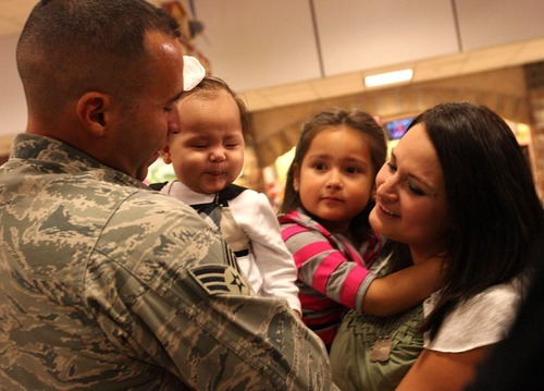 Leah Hogsten  |  The Salt Lake Tribune
Senior Airman Geiber Rea greets his daughter Amelie, 5 months, for the first time as his wife, Cecilia, holding their other daughter, Heather, 7, watches.