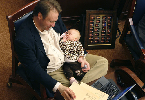 Scott Sommerdorf  |  The Salt Lake Tribune
Senator MArk Madsen, R-Tooele sits at his desk in the Utah Senate at 8:30pm holding his infant daughter, Thursday, March 10, 2011.
