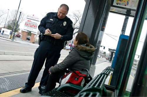 FRANCISCO KJOLSETH  |  Tribune File Photo
Utah Transit Authority officer Lloyd Davis writes a woman without a TRAX ticket a citation for $134 in this 2010 photo. UTA is in talks with Salt Lake County Jim Winder exploring a merger of law enforcement services for the transit agency.
